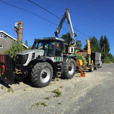 Bilde av traktorkvern festet bak traktor på vei